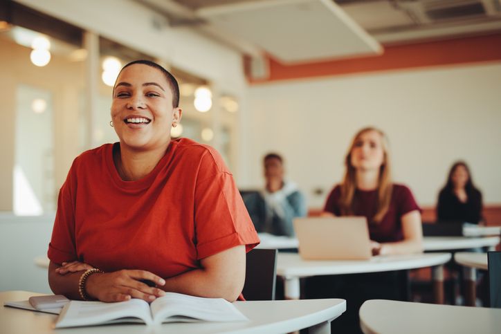 Adult education woman smiling at desk in class. 